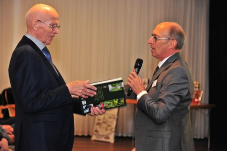Prof. Schröder überreicht Herr Meyer ein Buch